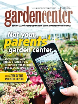 Garden Center magazine's October 2013 cover image of a person holding a phone taking a photo at a garden center