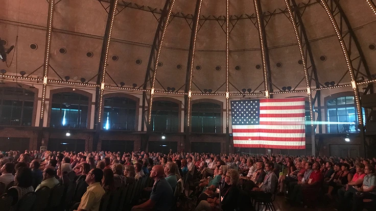 Room of people and an American flag hanging