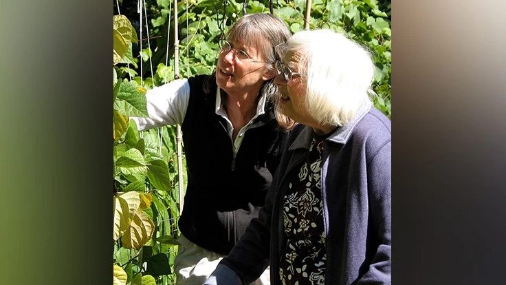 Horticultural Therapist, Patty Cassidy, works with a frail elder in the garden.