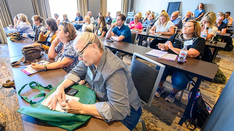 People sit at tables in a conference room.