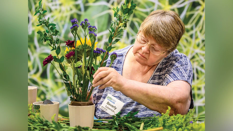 A person arranges flowers in a pot.