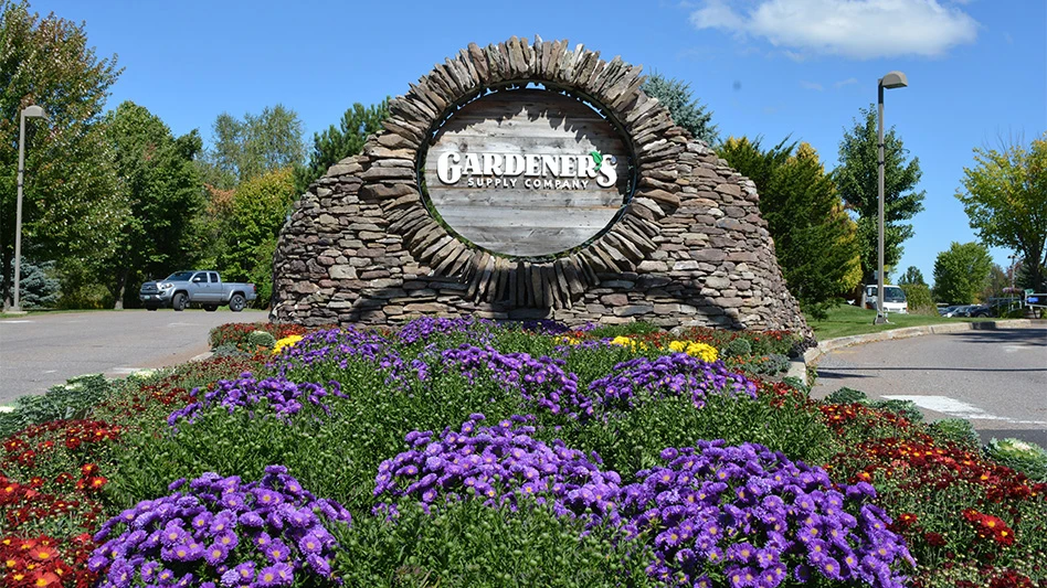 Stone sign that reads Gardener's Supply Company sitting on front of a flower bed.