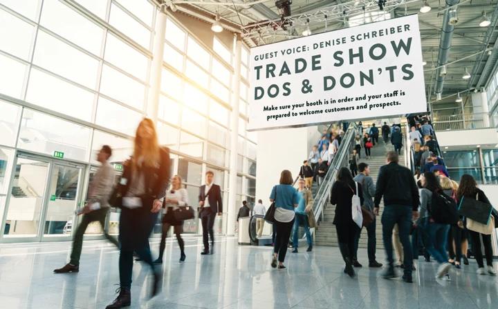 People walking on a trade show floor.
